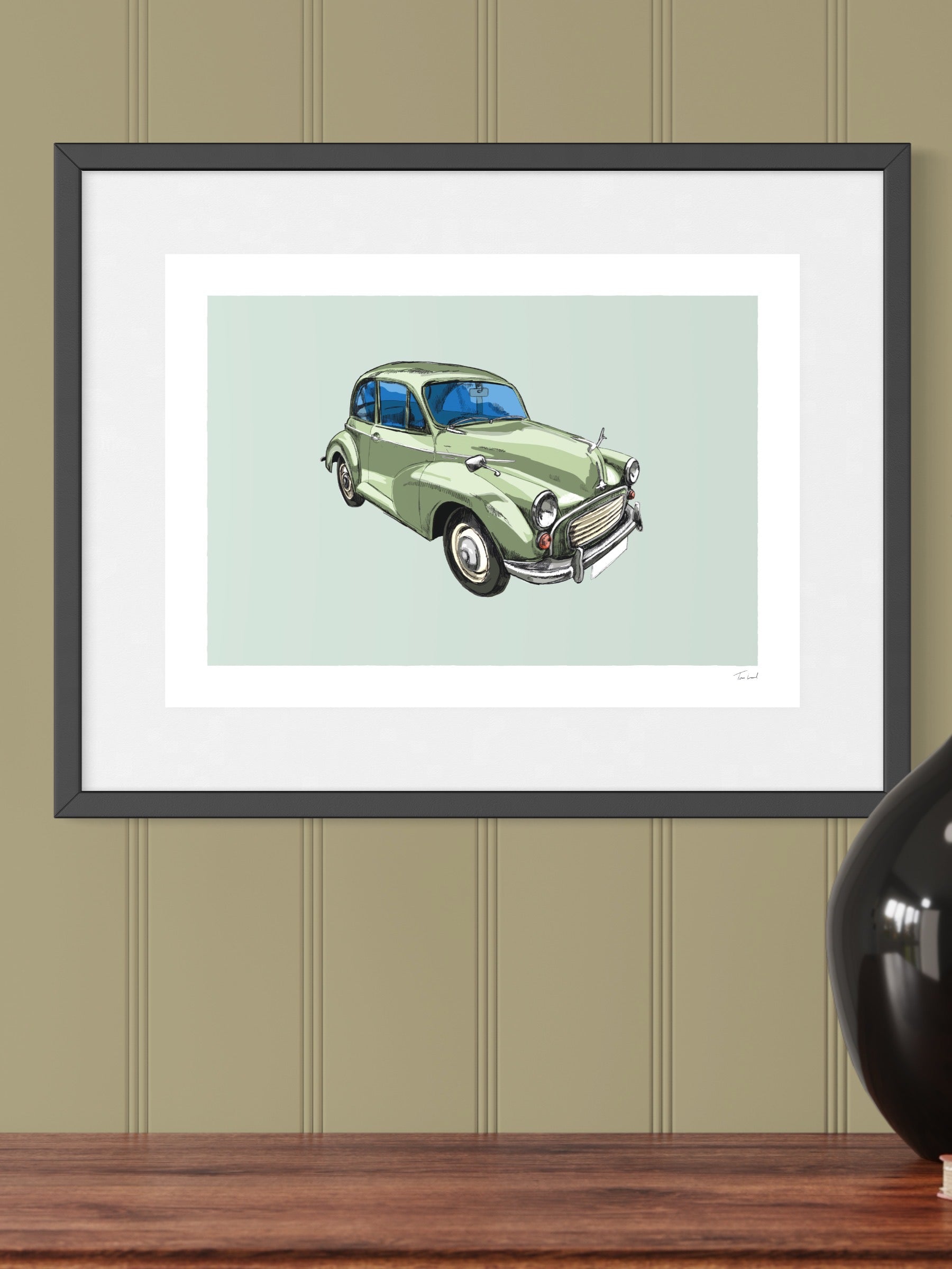 This image shows a giclee wall art print by Tom Laird Illustration of the British classic car, the Morris Minor, framed in a beautiful living room with tasteful modern home decor. This art print of a green example is available from Tom Laird Illustration in a variety of sizes.