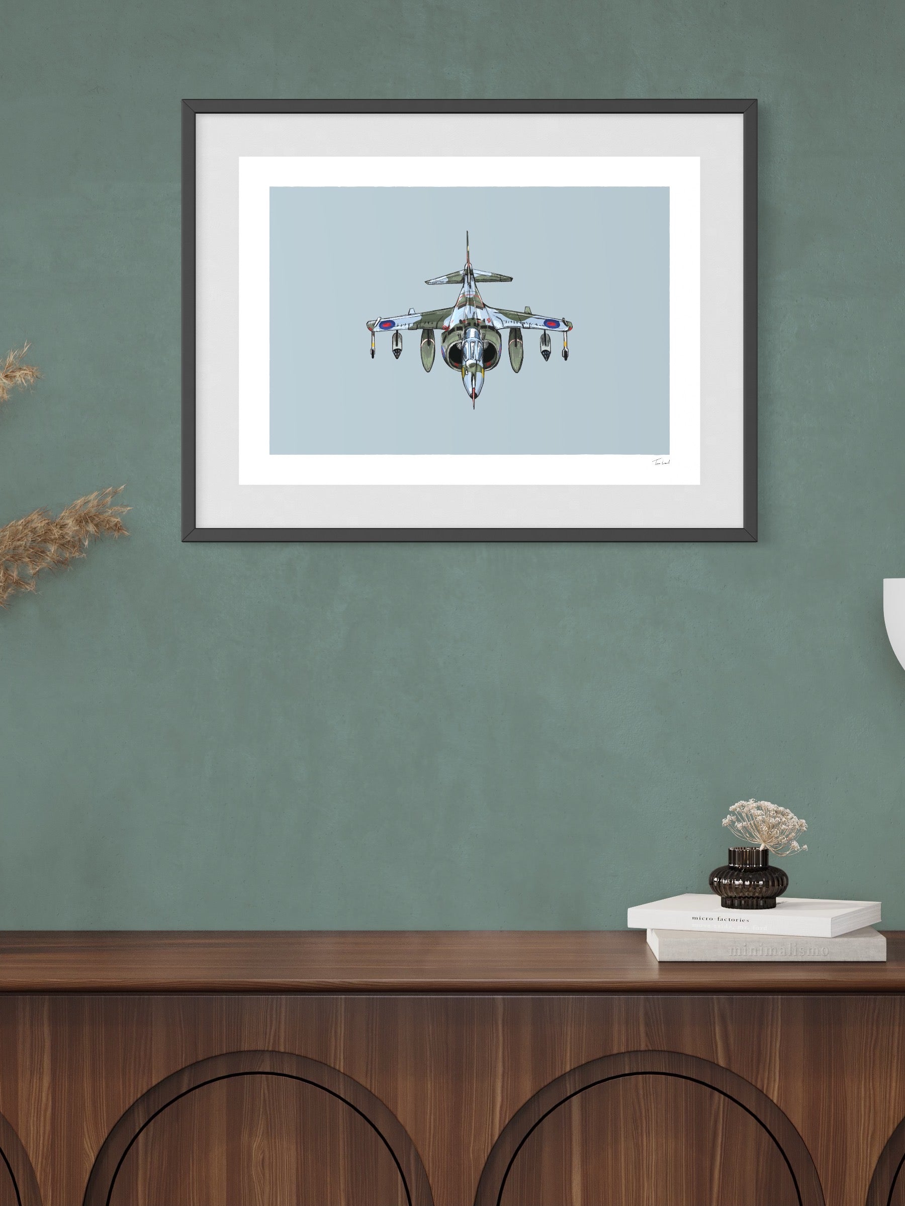 This image shows a giclee wall art print by Tom Laird Illustration of the British classic plane, the Harrier, framed in a beautiful living room with tasteful modern home decor. This art print is available from Tom Laird Illustration in a variety of sizes.