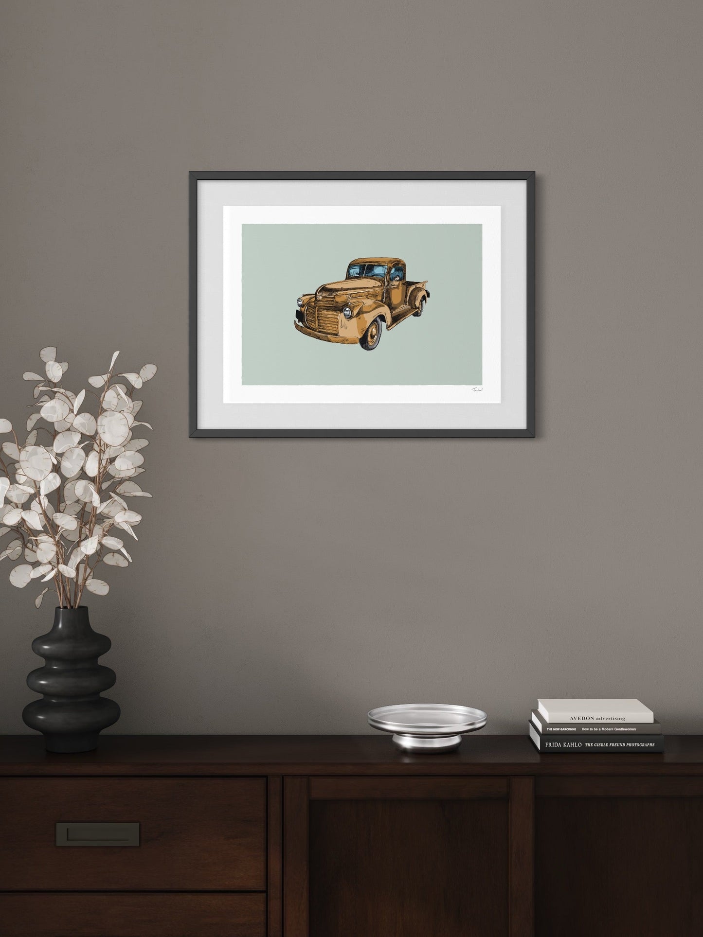 This image shows a giclee wall art print by Tom Laird Illustration of the American classic car, the GMC pickup, framed in a beautiful living room with tasteful modern home decor. This art print of a rusty brown example is available from Tom Laird Illustration in a variety of sizes.