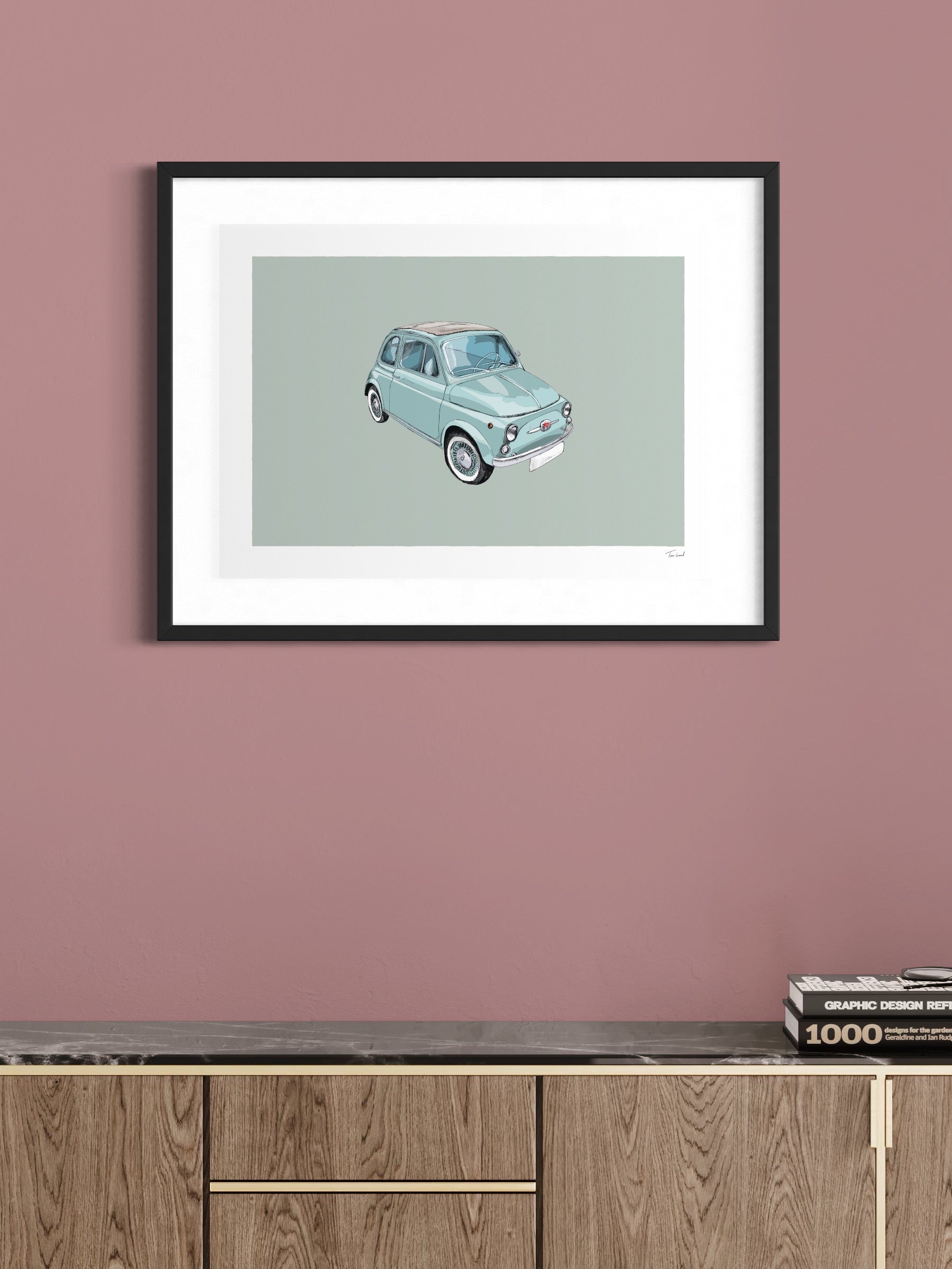 This image shows a giclee wall art print by Tom Laird Illustration of the Italian classic car, the Fiat 500, framed in a beautiful living room with tasteful modern home decor. This art print of a blue example is available from Tom Laird Illustration in a variety of sizes.