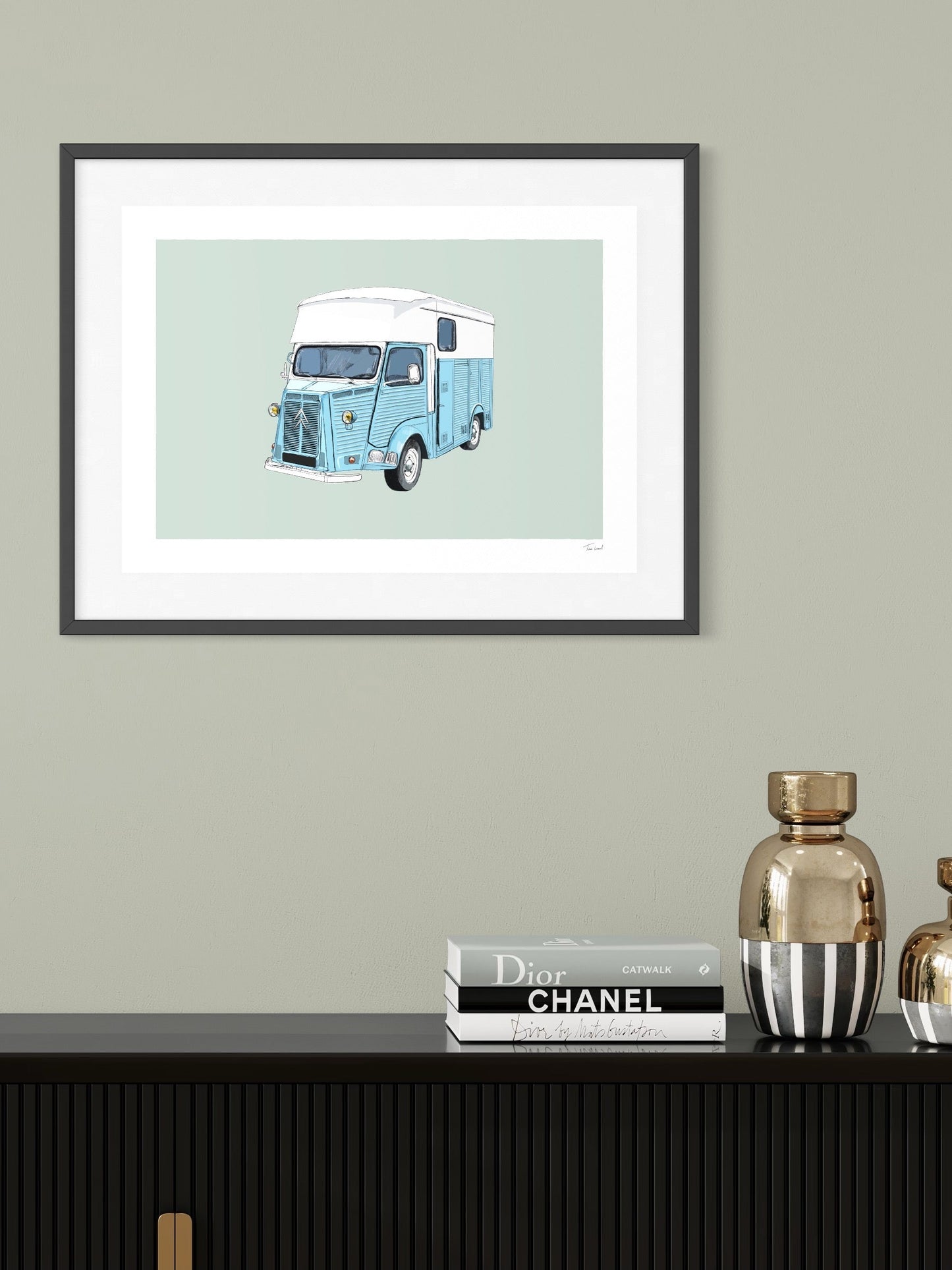 This image shows a giclee wall art print by Tom Laird Illustration of the French classic car, the Citroen HY Van, framed in a beautiful living room with tasteful modern home decor. This art print of a blue and white example is available from Tom Laird Illustration in a variety of sizes.