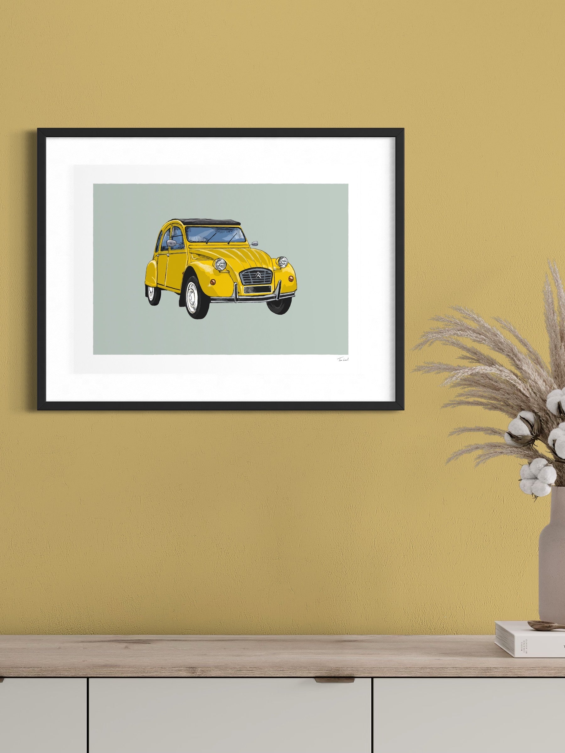 This image shows a giclee wall art print by Tom Laird Illustration of the French classic car, the Citroen 2CV, framed in a beautiful living room with tasteful modern home decor. This art print of a yellow example is available from Tom Laird Illustration in a variety of sizes.