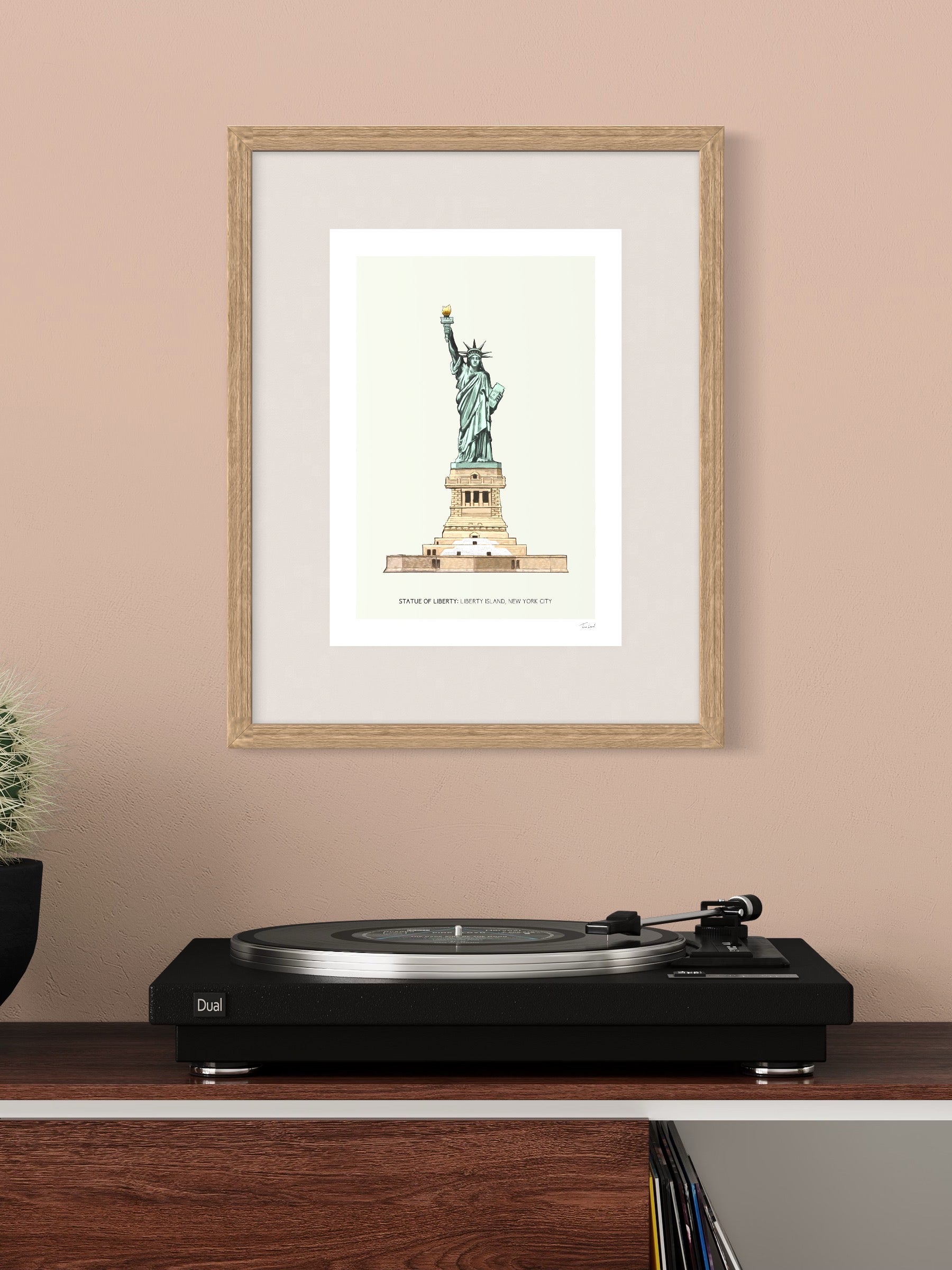 This image shows a giclee wall art print by Tom Laird Illustration of the world-famous New York City landmark the Statue of Liberty, framed in a beautiful living room with tasteful modern home decor. This art print is available from Tom Laird Illustration in A4 size.