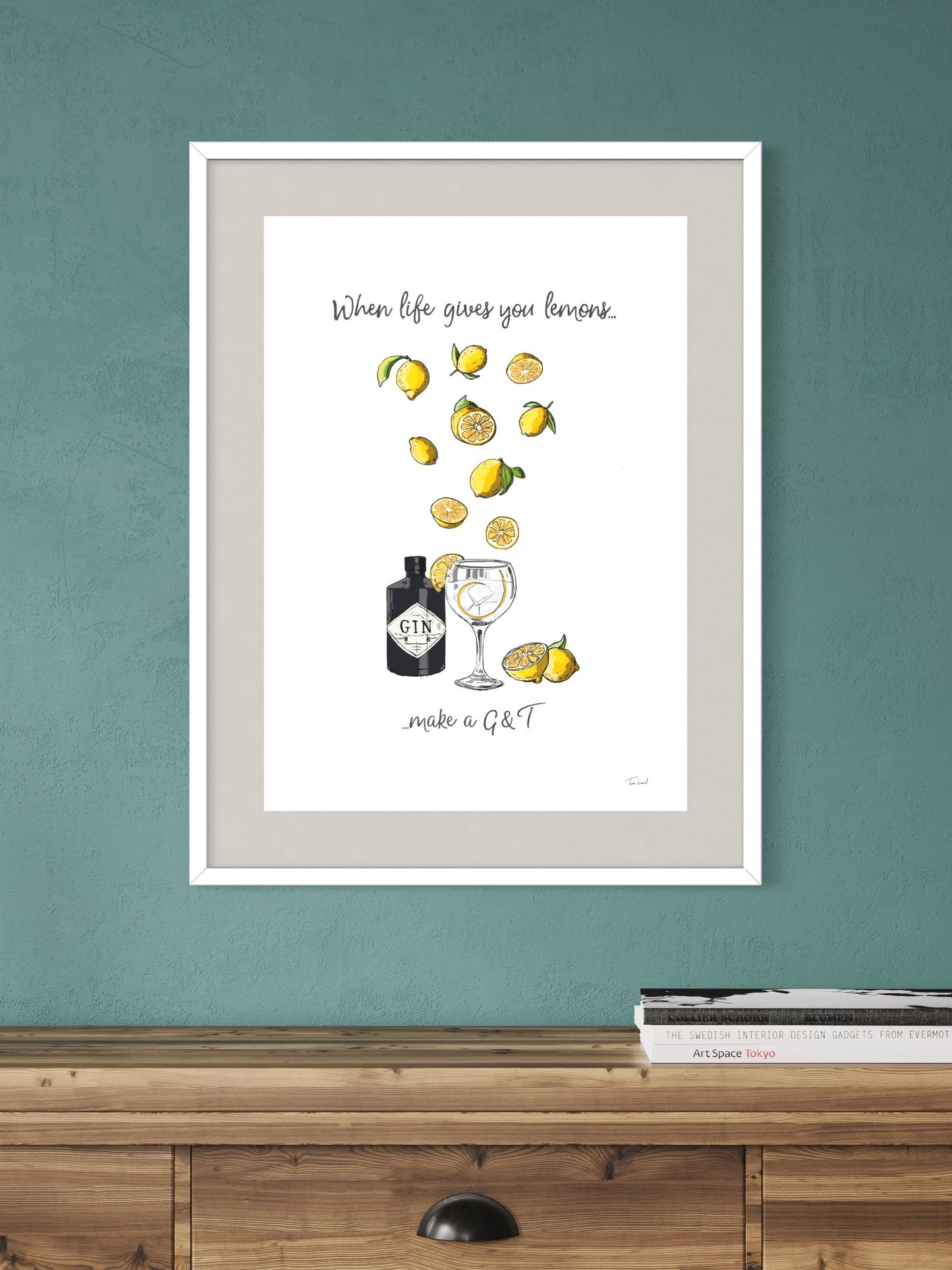 This image shows a giclee wall art print by Tom Laird Illustration of gin and lemons for the gin lover in your life, framed in a beautiful living room with tasteful modern home decor. This art print is available from Tom Laird Illustration in various sizes.