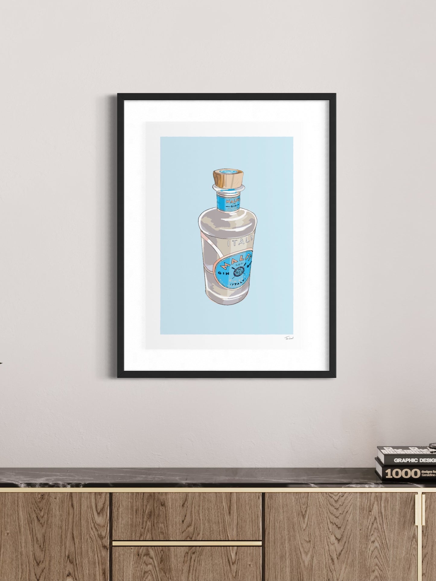 This image shows a giclee wall art print by Tom Laird Illustration of a Malfy Gin Bottle, framed in a beautiful living room with tasteful modern home decor. This art print is available from Tom Laird Illustration in various sizes.