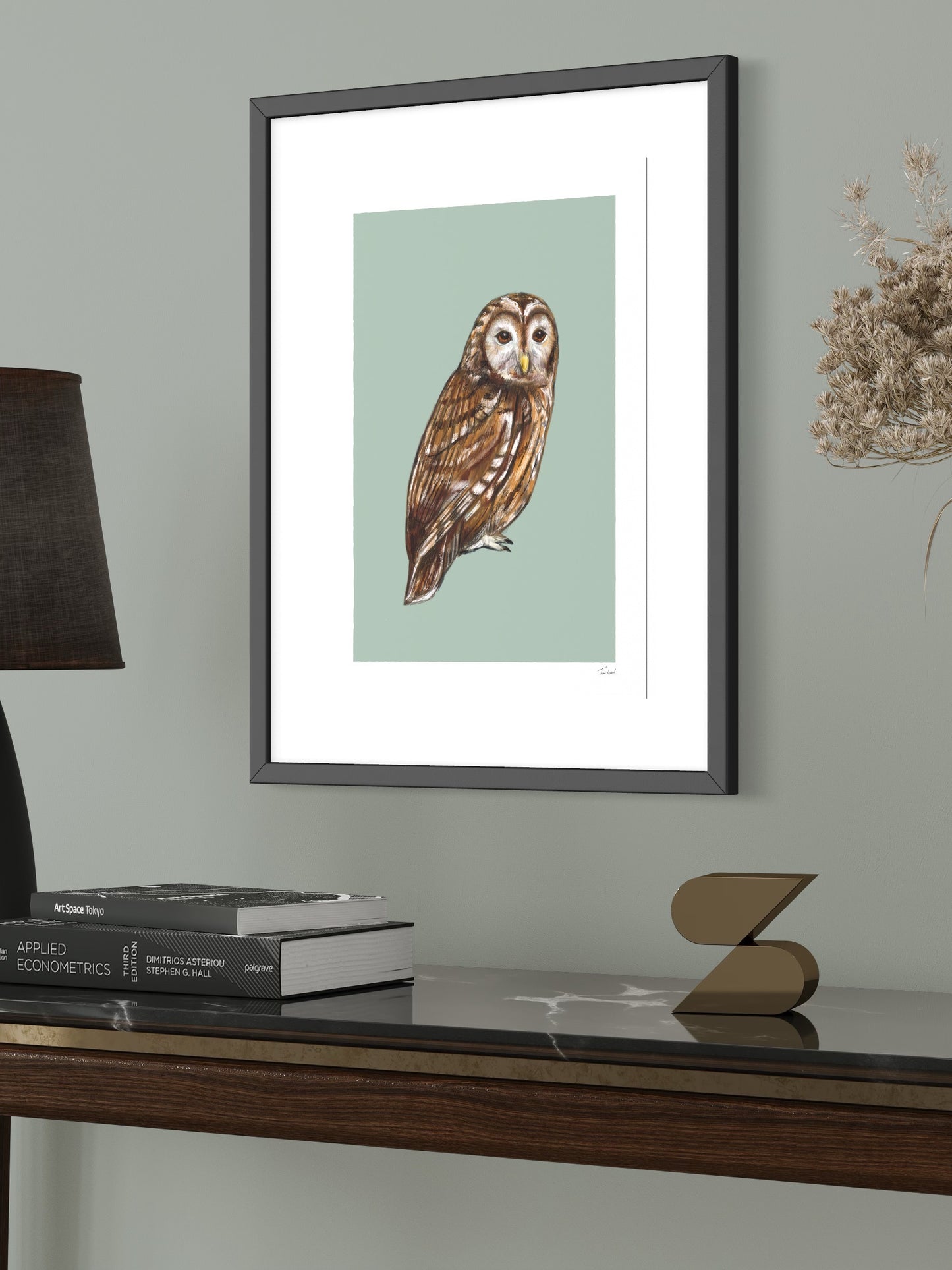 This image shows a giclee wall art print by Tom Laird Illustration of a Tawny Owl, framed in a beautiful living room with tasteful modern home decor. This art print is available from Tom Laird Illustration in various sizes.